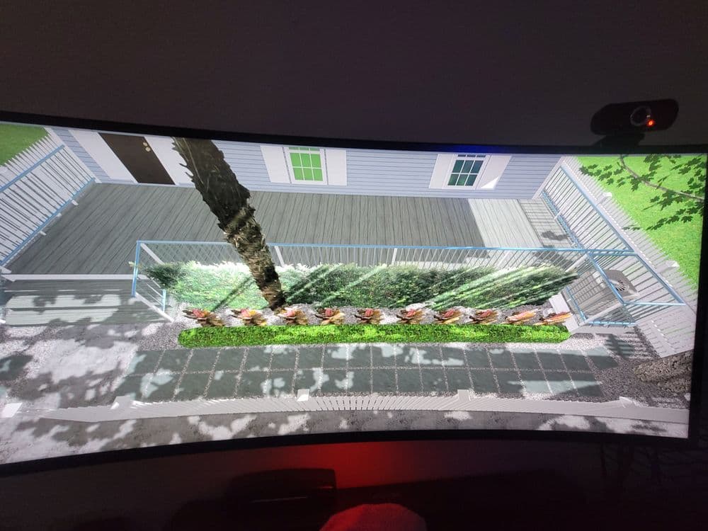 3D render of a modern deck with glass railing and landscaped green space.